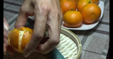 Sepetteki mandalinayı soy.