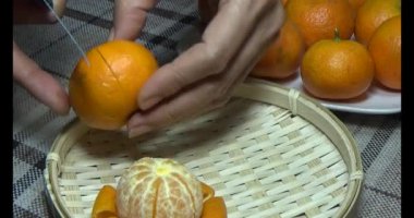 Sepetteki mandalinayı soy.