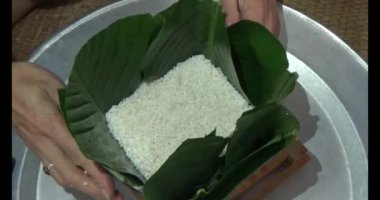 Vietnam 'da Chung keki yapan kadın. Banh chung gübre yapraklarıyla sarılmış, yapışkan pirinç, et ve fasulye.
