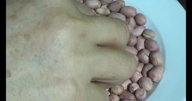 Adam kavrulmuş fıstık yiyor.