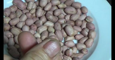 Adam kavrulmuş fıstık yiyor.