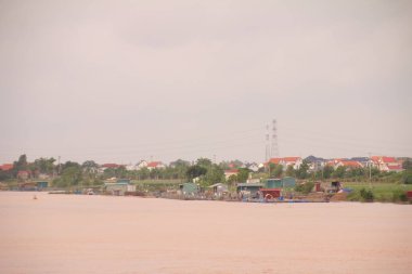 Nehir Vietnam 'da. Nehirde kayıklar ve gemiler, kıyılarda kırsal köyler, balık kafesleri, sebze tarlaları var.