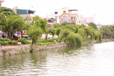 Nehir Vietnam 'da. Nehirde kayıklar ve gemiler, kıyılarda kırsal köyler, balık kafesleri, sebze tarlaları var.