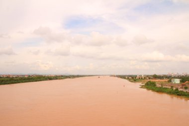 Nehir Vietnam 'da. Nehirde kayıklar ve gemiler, kıyılarda kırsal köyler, balık kafesleri, sebze tarlaları var.