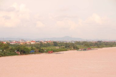 Nehir Vietnam 'da. Nehirde kayıklar ve gemiler, kıyılarda kırsal köyler, balık kafesleri, sebze tarlaları var.