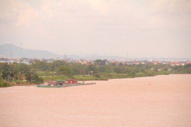 Nehir Vietnam 'da. Nehirde kayıklar ve gemiler, kıyılarda kırsal köyler, balık kafesleri, sebze tarlaları var.