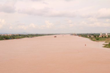 Nehir Vietnam 'da. Nehirde kayıklar ve gemiler, kıyılarda kırsal köyler, balık kafesleri, sebze tarlaları var.