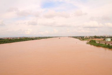 Nehir Vietnam 'da. Nehirde kayıklar ve gemiler, kıyılarda kırsal köyler, balık kafesleri, sebze tarlaları var.