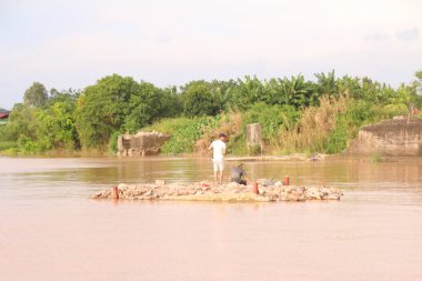 Nehir Vietnam 'da. Nehirde kayıklar ve gemiler, kıyılarda kırsal köyler, balık kafesleri, sebze tarlaları var.