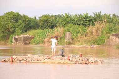 Nehir Vietnam 'da. Nehirde kayıklar ve gemiler, kıyılarda kırsal köyler, balık kafesleri, sebze tarlaları var.