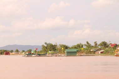 Nehir Vietnam 'da. Nehirde kayıklar ve gemiler, kıyılarda kırsal köyler, balık kafesleri, sebze tarlaları var.