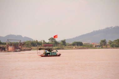 Nehir Vietnam 'da. Nehirde kayıklar ve gemiler, kıyılarda kırsal köyler, balık kafesleri, sebze tarlaları var.