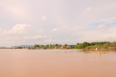 Nehir Vietnam 'da. Nehirde kayıklar ve gemiler, kıyılarda kırsal köyler, balık kafesleri, sebze tarlaları var.