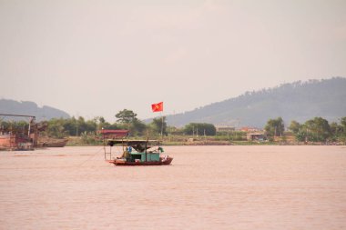 Nehir Vietnam 'da. Nehirde kayıklar ve gemiler, kıyılarda kırsal köyler, balık kafesleri, sebze tarlaları var.