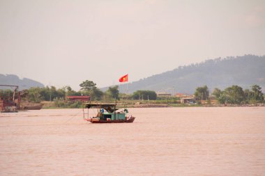 Nehir Vietnam 'da. Nehirde kayıklar ve gemiler, kıyılarda kırsal köyler, balık kafesleri, sebze tarlaları var.