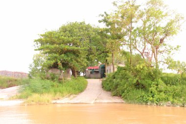 Nehir Vietnam 'da. Nehirde kayıklar ve gemiler, kıyılarda kırsal köyler, balık kafesleri, sebze tarlaları var.