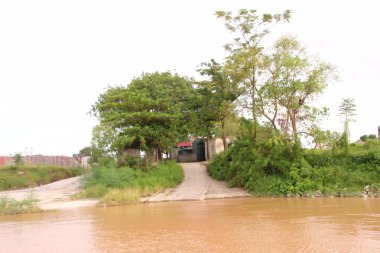 Nehir Vietnam 'da. Nehirde kayıklar ve gemiler, kıyılarda kırsal köyler, balık kafesleri, sebze tarlaları var.
