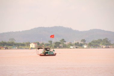 Nehir Vietnam 'da. Nehirde kayıklar ve gemiler, kıyılarda kırsal köyler, balık kafesleri, sebze tarlaları var.