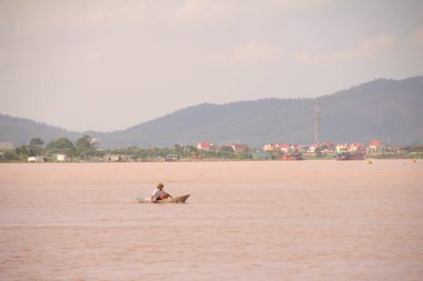 Nehir Vietnam 'da. Nehirde kayıklar ve gemiler, kıyılarda kırsal köyler, balık kafesleri, sebze tarlaları var.