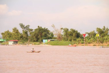 Nehir Vietnam 'da. Nehirde kayıklar ve gemiler, kıyılarda kırsal köyler, balık kafesleri, sebze tarlaları var.