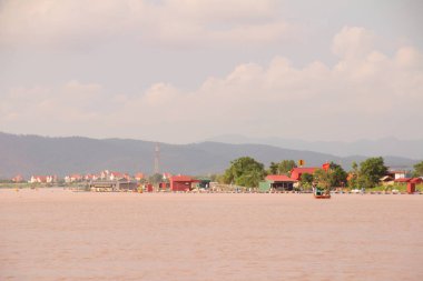 Nehir Vietnam 'da. Nehirde kayıklar ve gemiler, kıyılarda kırsal köyler, balık kafesleri, sebze tarlaları var.