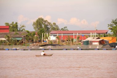 Nehir Vietnam 'da. Nehirde kayıklar ve gemiler, kıyılarda kırsal köyler, balık kafesleri, sebze tarlaları var.