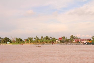 Nehir Vietnam 'da. Nehirde kayıklar ve gemiler, kıyılarda kırsal köyler, balık kafesleri, sebze tarlaları var.