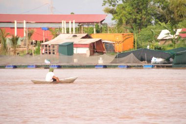 Nehir Vietnam 'da. Nehirde kayıklar ve gemiler, kıyılarda kırsal köyler, balık kafesleri, sebze tarlaları var.