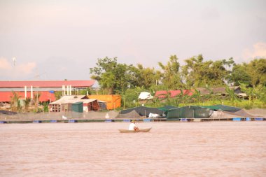 Nehir Vietnam 'da. Nehirde kayıklar ve gemiler, kıyılarda kırsal köyler, balık kafesleri, sebze tarlaları var.