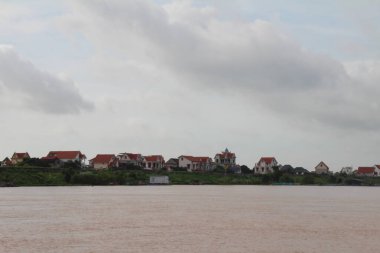 Nehir Vietnam 'da. Nehirde kayıklar ve gemiler, kıyılarda kırsal köyler, balık kafesleri, sebze tarlaları var.