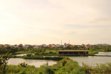 Nehir Vietnam 'da. Nehirde kayıklar ve gemiler, kıyılarda kırsal köyler, balık kafesleri, sebze tarlaları var.
