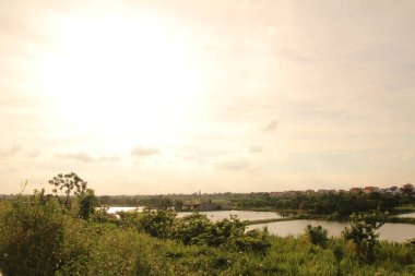 Nehir Vietnam 'da. Nehirde kayıklar ve gemiler, kıyılarda kırsal köyler, balık kafesleri, sebze tarlaları var.