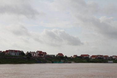 Nehir Vietnam 'da. Nehirde kayıklar ve gemiler, kıyılarda kırsal köyler, balık kafesleri, sebze tarlaları var.