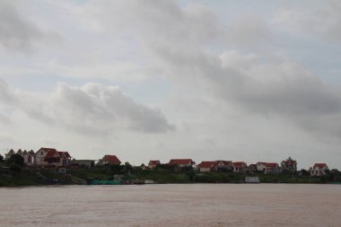 Nehir Vietnam 'da. Nehirde kayıklar ve gemiler, kıyılarda kırsal köyler, balık kafesleri, sebze tarlaları var.