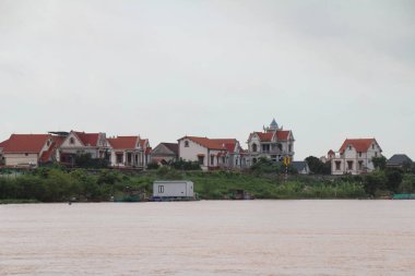 Nehir Vietnam 'da. Nehirde kayıklar ve gemiler, kıyılarda kırsal köyler, balık kafesleri, sebze tarlaları var.