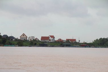 Nehir Vietnam 'da. Nehirde kayıklar ve gemiler, kıyılarda kırsal köyler, balık kafesleri, sebze tarlaları var.