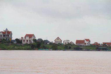 Nehir Vietnam 'da. Nehirde kayıklar ve gemiler, kıyılarda kırsal köyler, balık kafesleri, sebze tarlaları var.