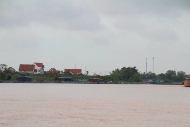 Nehir Vietnam 'da. Nehirde kayıklar ve gemiler, kıyılarda kırsal köyler, balık kafesleri, sebze tarlaları var.