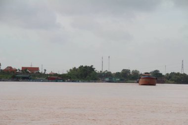 Nehir Vietnam 'da. Nehirde kayıklar ve gemiler, kıyılarda kırsal köyler, balık kafesleri, sebze tarlaları var.