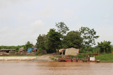 Nehir Vietnam 'da. Nehirde kayıklar ve gemiler, kıyılarda kırsal köyler, balık kafesleri, sebze tarlaları var.