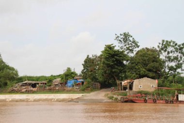 Nehir Vietnam 'da. Nehirde kayıklar ve gemiler, kıyılarda kırsal köyler, balık kafesleri, sebze tarlaları var.