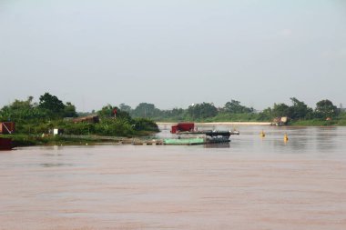 Nehir Vietnam 'da. Nehirde kayıklar ve gemiler, kıyılarda kırsal köyler, balık kafesleri, sebze tarlaları var.