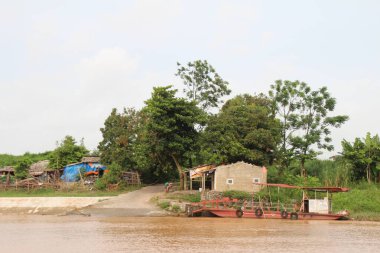 Nehir Vietnam 'da. Nehirde kayıklar ve gemiler, kıyılarda kırsal köyler, balık kafesleri, sebze tarlaları var.