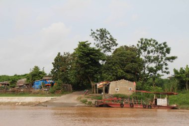 Nehir Vietnam 'da. Nehirde kayıklar ve gemiler, kıyılarda kırsal köyler, balık kafesleri, sebze tarlaları var.