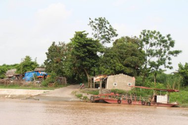 Nehir Vietnam 'da. Nehirde kayıklar ve gemiler, kıyılarda kırsal köyler, balık kafesleri, sebze tarlaları var.