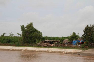 Nehir Vietnam 'da. Nehirde kayıklar ve gemiler, kıyılarda kırsal köyler, balık kafesleri, sebze tarlaları var.