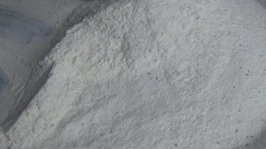 Çiftçinin eli un temizlemek için sepeti kullanıyor.