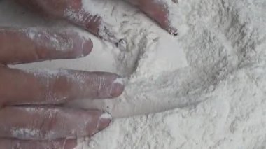 Çiftçinin eli un temizlemek için sepeti kullanıyor.