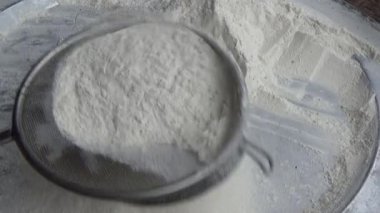 Çiftçinin eli un temizlemek için sepeti kullanıyor.