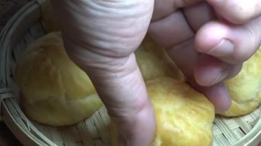 Çiftçinin eli un temizlemek için sepeti kullanıyor.